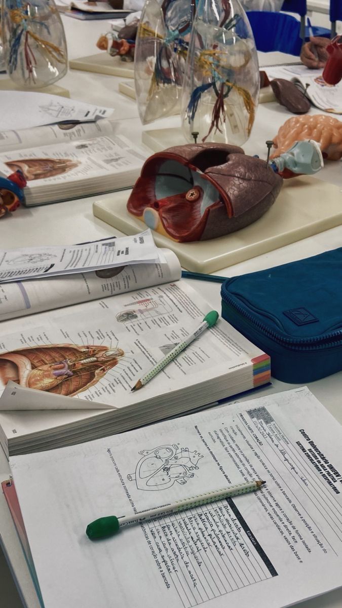 the table is covered with many different types of medical equipment and books, including an open notebook