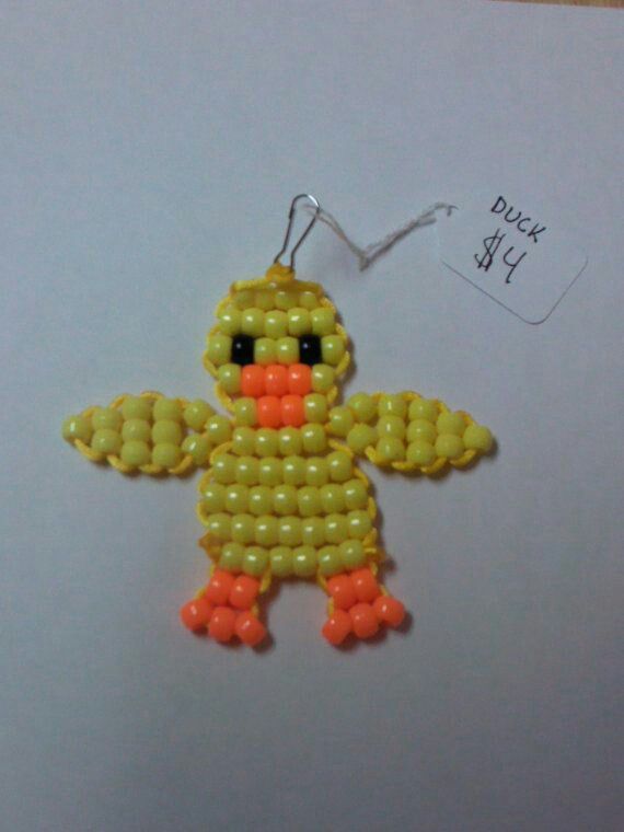 an ornament made to look like a ducky with yellow beads on it