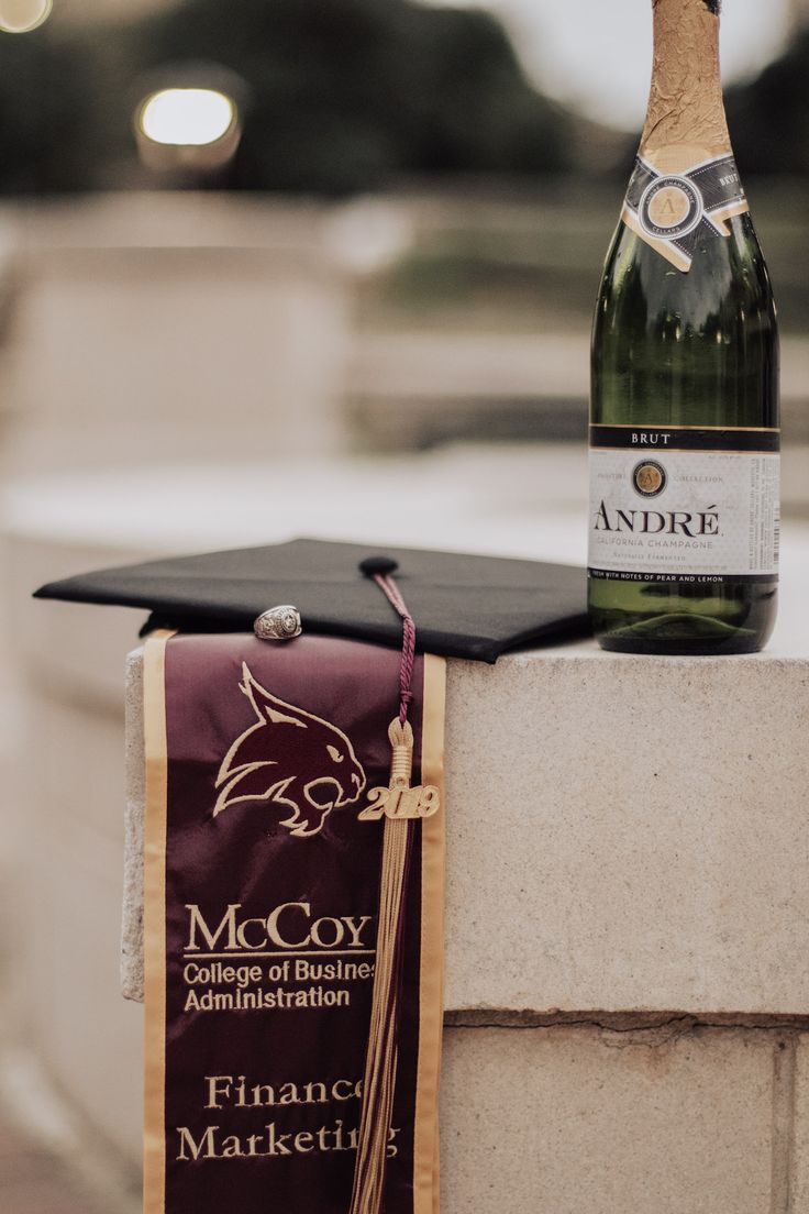 a graduation cap on top of a bottle of wine