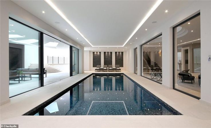 an indoor swimming pool with glass doors leading into the living room