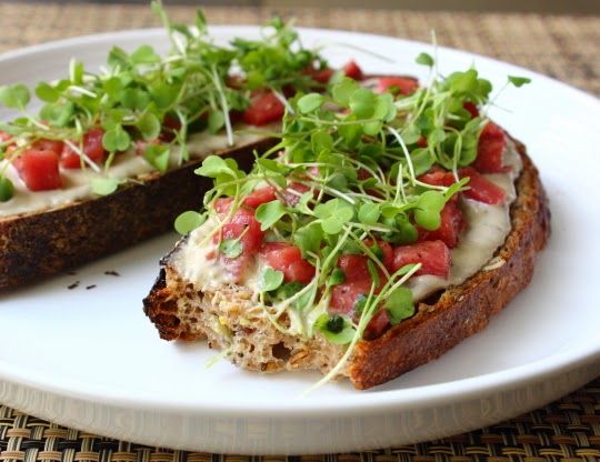 a white plate topped with bread covered in veggies