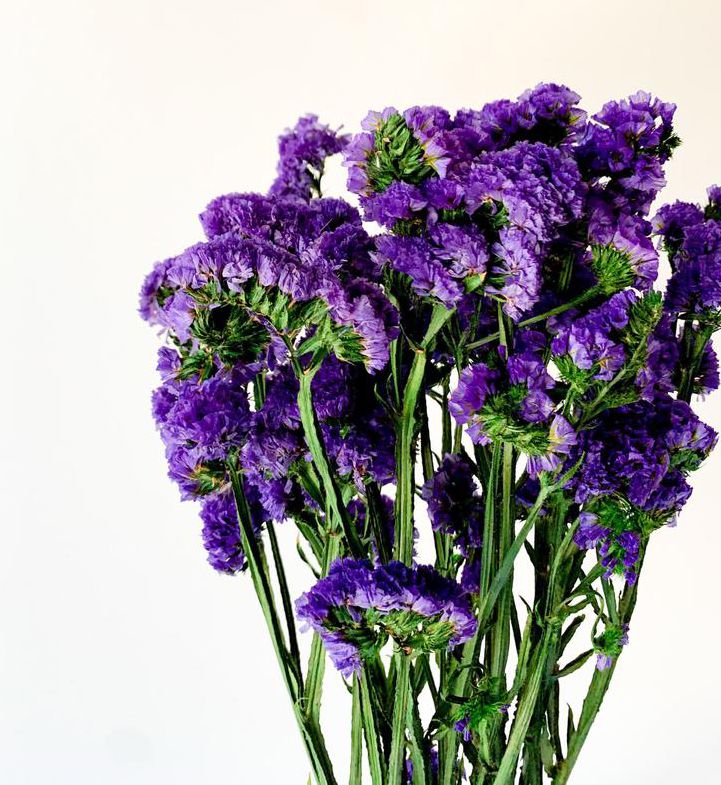 purple flowers are in a glass vase on a table