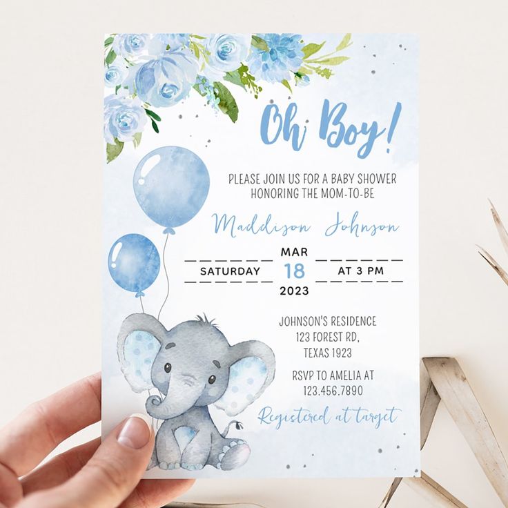 a baby shower is being held up by someone's hand with an elephant and balloons on it