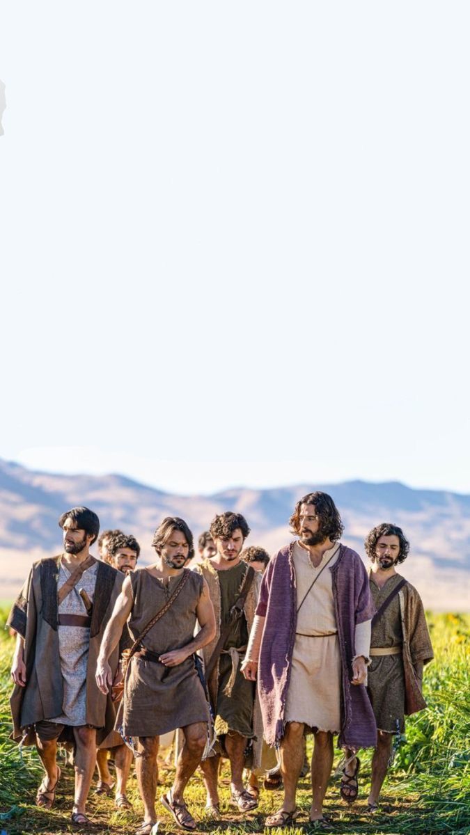 a group of men walking across a lush green field