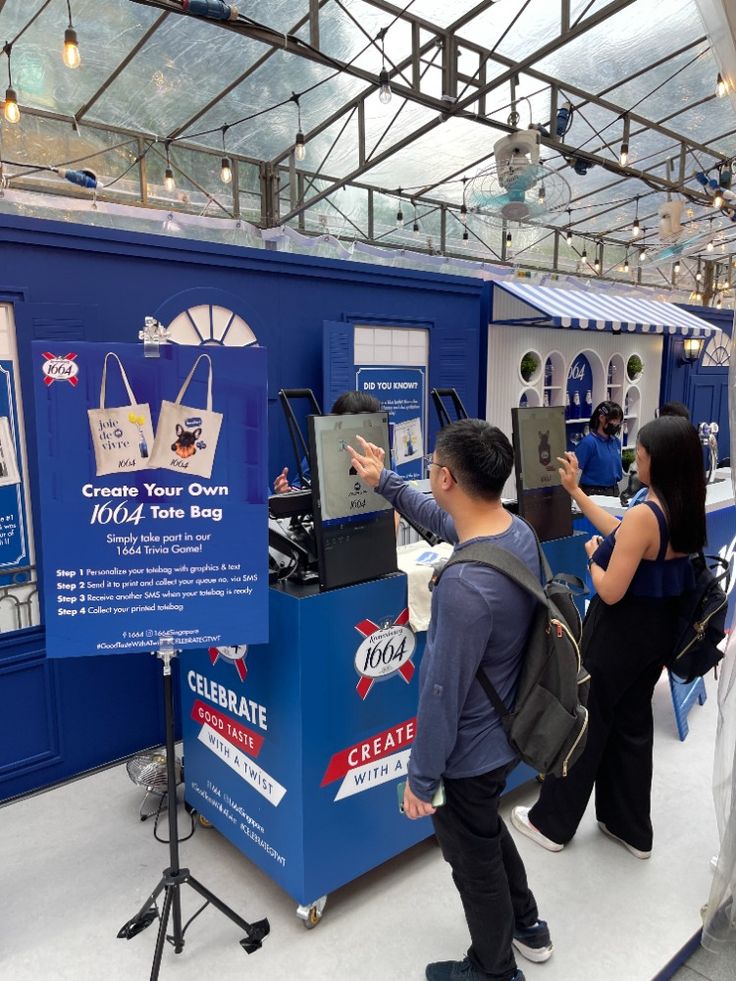 two people standing in front of a blue booth