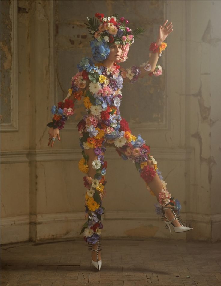 a woman with flowers on her body and heels