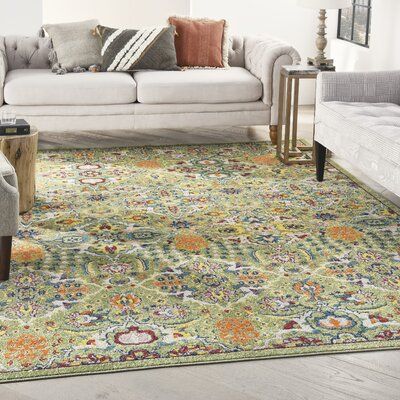 a living room filled with furniture and a rug on top of a wooden floor next to a white couch