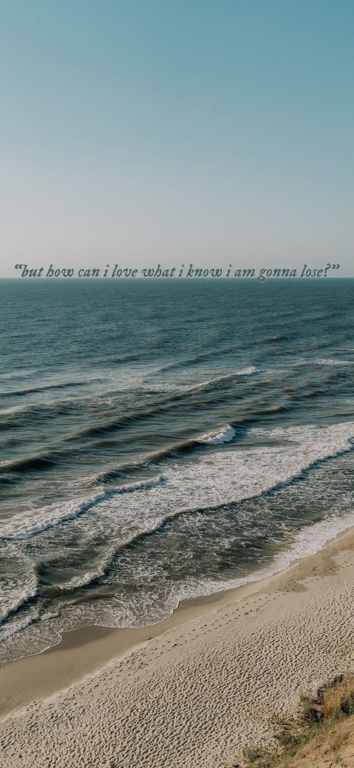 an ocean view with a quote written on the sand and waves coming in to shore