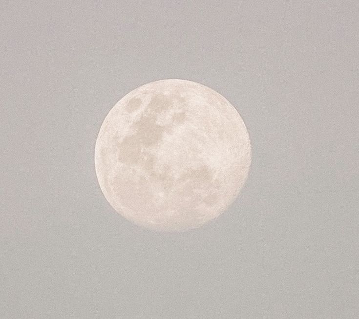 an airplane is flying in front of the moon on a cloudy day with no clouds