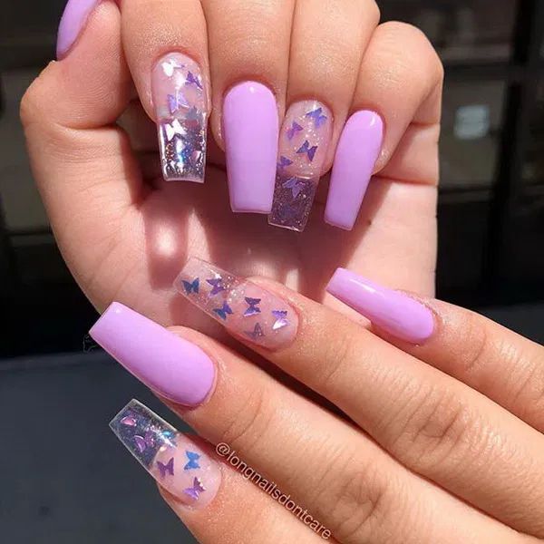 someone is holding up their nails with purple and silver stars on them, while the other hand