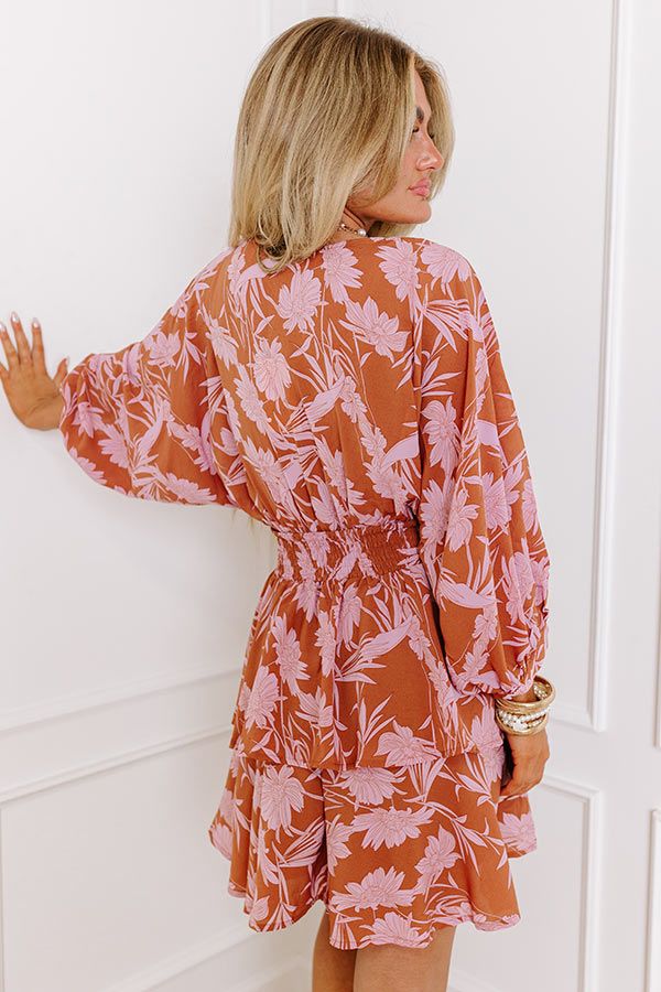 - Move into your boho babe era with this gorgeous dress! - Lightweight material with a pink hued floral print - A v-cut neckline - Long, oversized sleeves - A stretchy smocked waistline - A tiered skirt with a built-in lining - A flowy yet flattering silhouette that ends in a mid-thigh length hemline Printed Floral Dress For Fall Vacation, Pink Flowy Boho Dress With Floral Print, Fall Beach Boho Dress With Floral Print, Fall Boho Dress With Floral Print For Beach, Pink Floral Print Boho Dress For Day Out, Pink Floral Boho Dress For Day Out, Flowy Floral Dress For Fall Vacation, Fall Beach Floral Print Dress, Pink Boho Dress For Beach In Fall