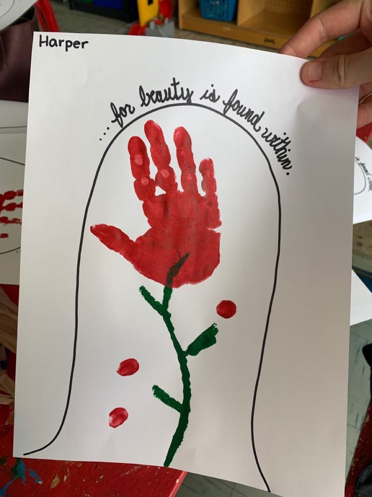 a child's handprint with a red flower on it