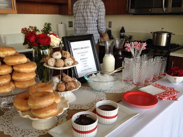 a table topped with donuts and cups filled with chocolate sauce next to a man standing in the background