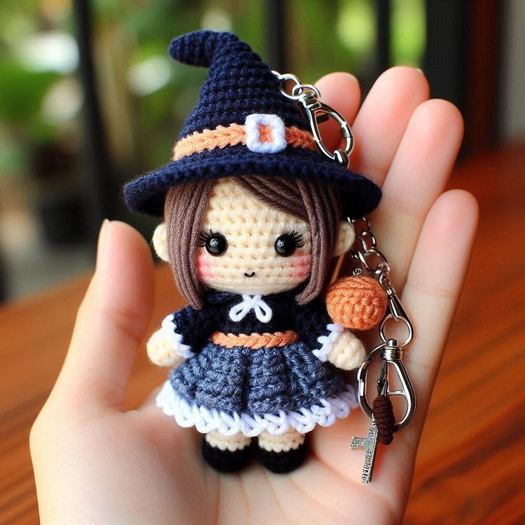 a tiny doll wearing a witches hat and holding a keychain in her hand