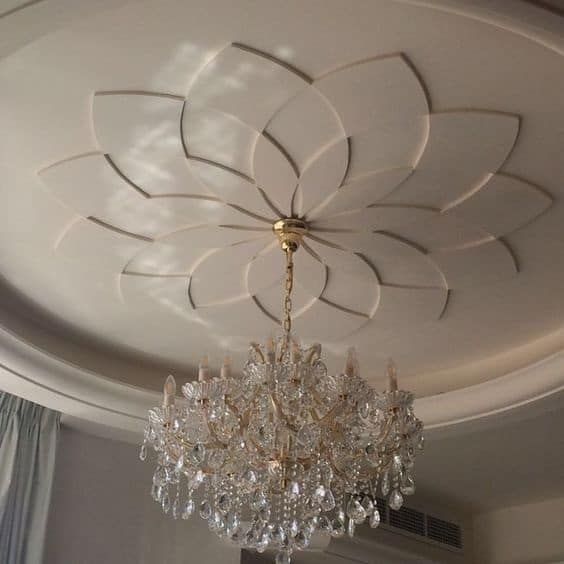 a chandelier hanging from the ceiling in a room with white walls and curtains