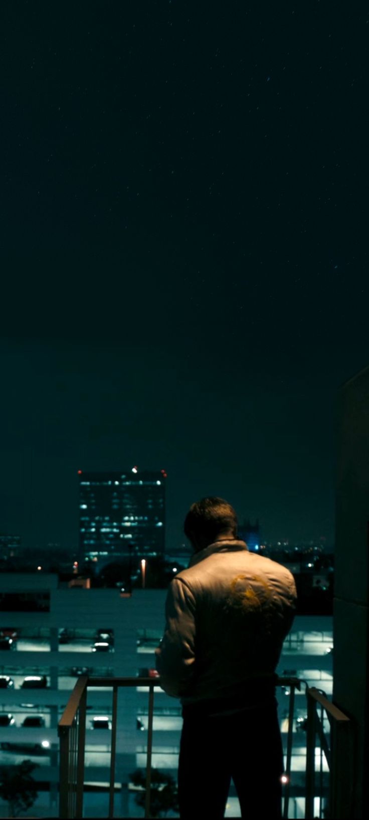 a man standing on top of a building at night