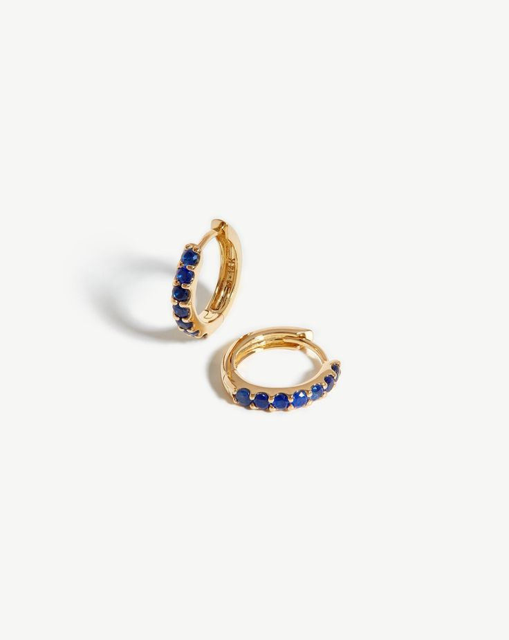 Fine Sapphire Huggies 14ct Solid Gold/Sapphire. Everyday Huggies, Elevated. These Mini Hoop Earrings are Inset with Blue Sapphires and Open with a Hinge. Pair with 14Ct Solid Gold Huggies for a Refined Ear Stack. Crafted from 100% Recycled Gold, and Hallmarked for Authenticity. Metal: 14Ct Recycled Solid Gold Gemstone: Blue Sapphire, with Quality 0. 56Ct Dimensions: 11mm X 2. 07mm Weight: 1. 4g this Piece is Handcrafted with Recycled Metal Elements to Help us Reduce Our Environmental Impact. Pro Double Chain Bracelet, Gold Huggies, Malachite Necklace, Ear Stack, Mini Hoop Earrings, Pearl Pendant Necklace, Recycled Gold, Recycled Sterling Silver, Conflict Free Diamonds