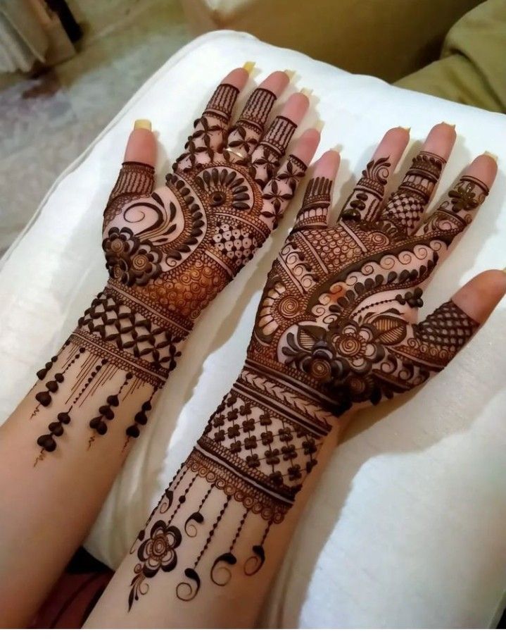 two hands with henna designs on them