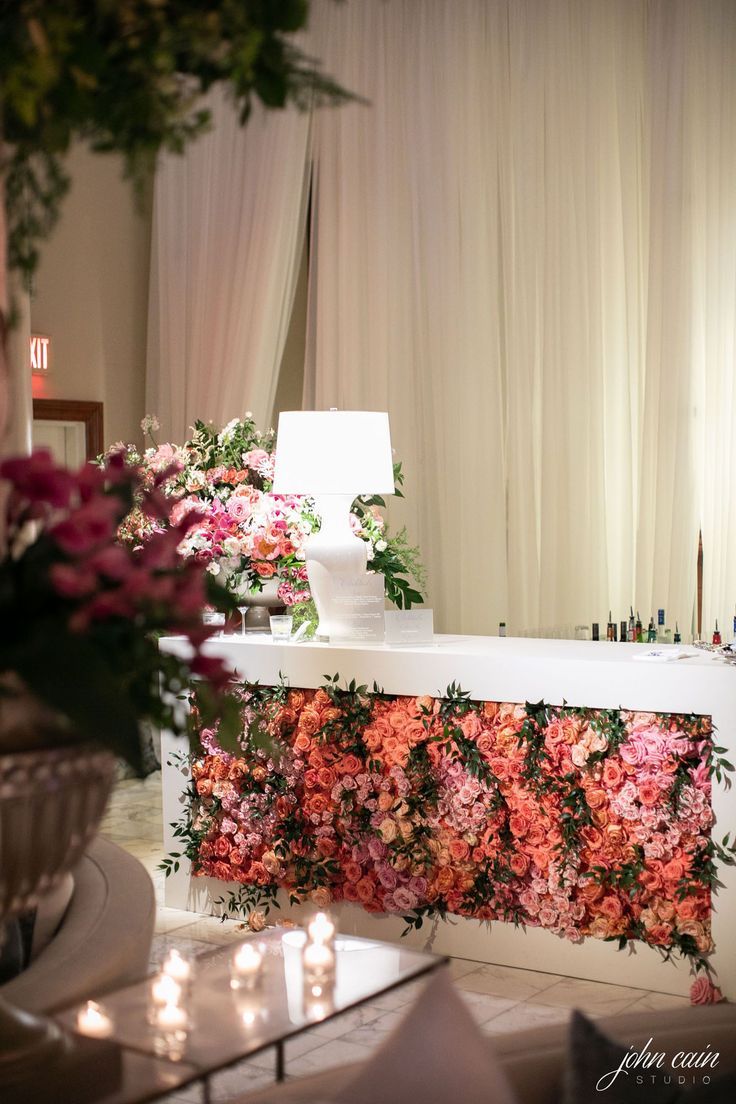 a flower covered counter with candles and flowers on it