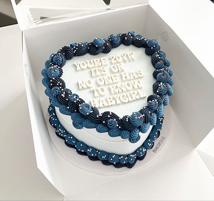 a white and blue cake in a box with writing on the top that says, you're 25 % off no one has to know baby