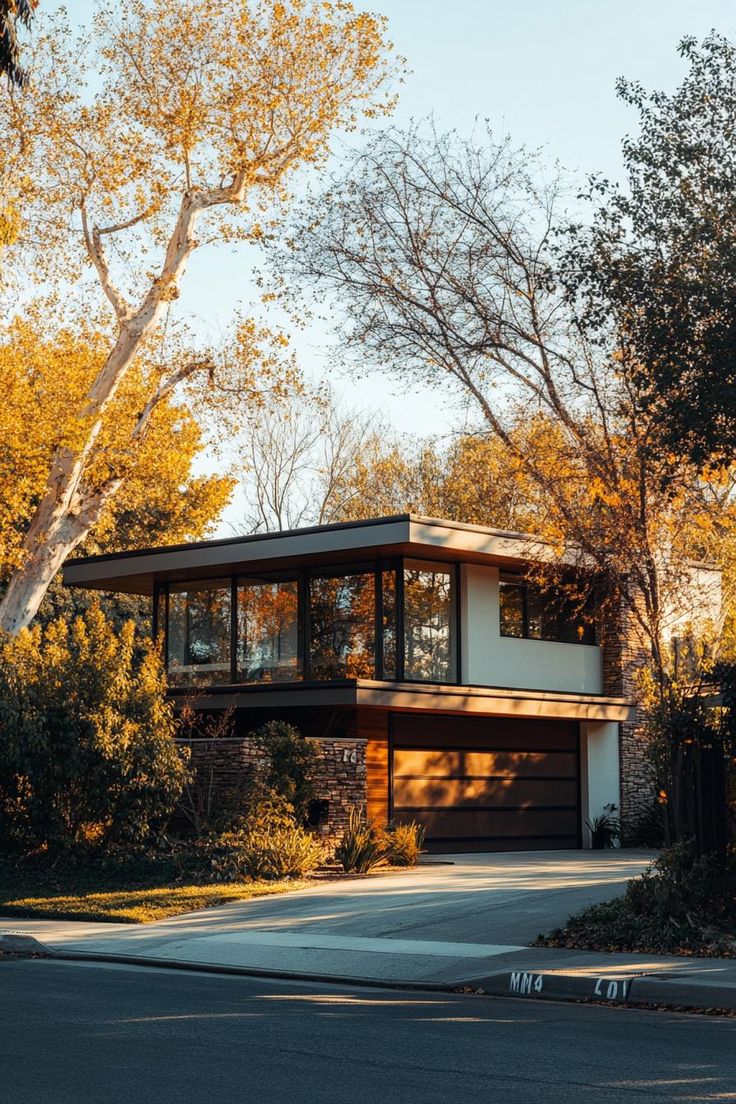 a modern house with lots of windows and trees