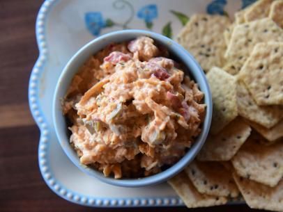 a bowl of dip and crackers on a plate