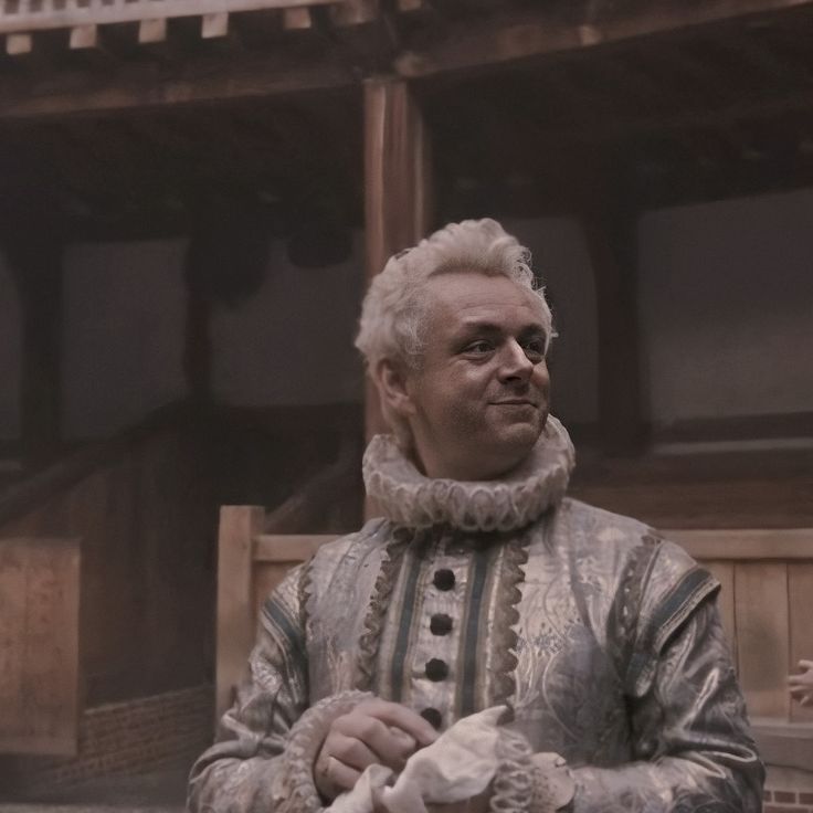 an older man with white hair is standing in front of a building and holding a stuffed animal