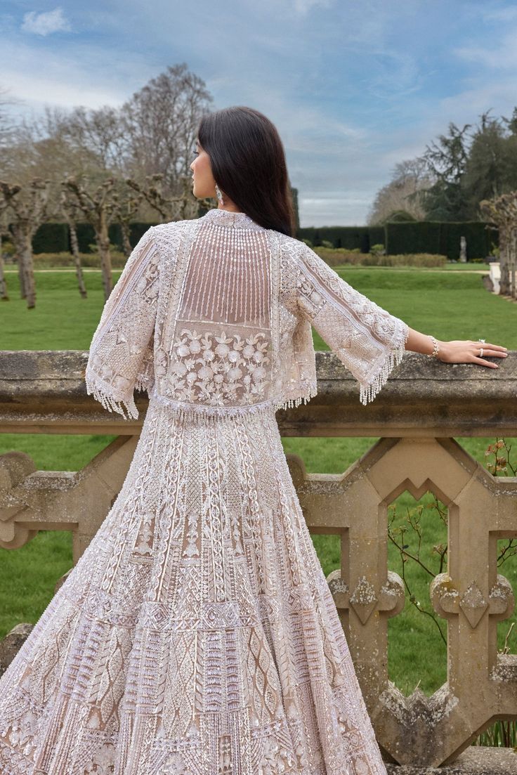 This jacket lehenga set features embroidery in white and silver sequin and crystal on a nude base. The strappy blouse is fully embroidered and shows tassels at the waist. The ensemble is paired with a matching flowy jacket.From Seema Gujral's A Royal Affair collection. DELIVERY TIMEPlease allow 8-12 weeks for your outfit to arrive. FABRIC DETAILSNet Professional cleaning only. Short Jacket Style Lehenga, Lehenga With Jacket, Flowy Jacket, Full Sleeves Blouse Designs, Strappy Blouse, Jacket Lehenga, A Royal Affair, Function Dresses, Full Sleeve Blouse