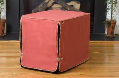 a red box sitting on top of a hard wood floor next to a fire place