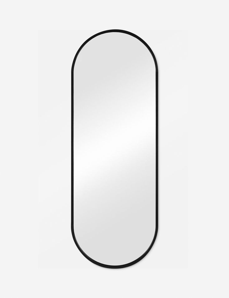 an oval mirror with black frame on a white wall, in the shape of a rectangle