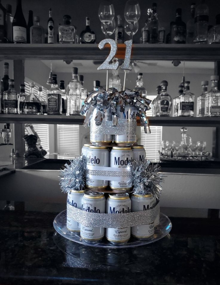 a tiered cake made out of cans with silver decorations on top and the number twenty