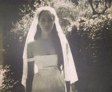 an old photo of a woman in a wedding dress with a veil over her head