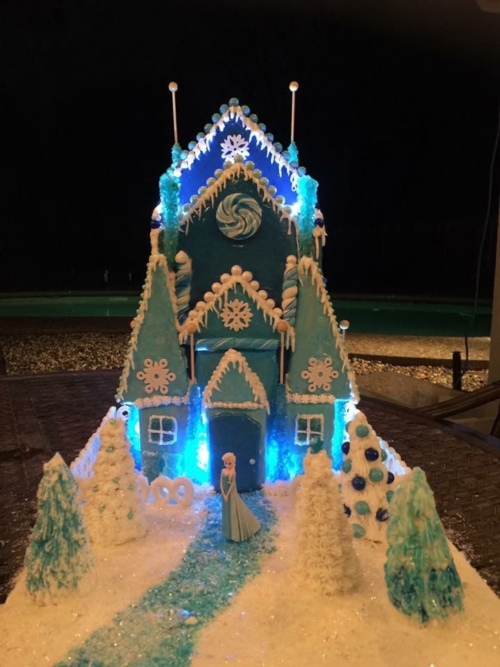 a gingerbread house decorated with blue and white lights