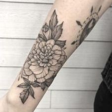 a woman's arm with a flower tattoo on it