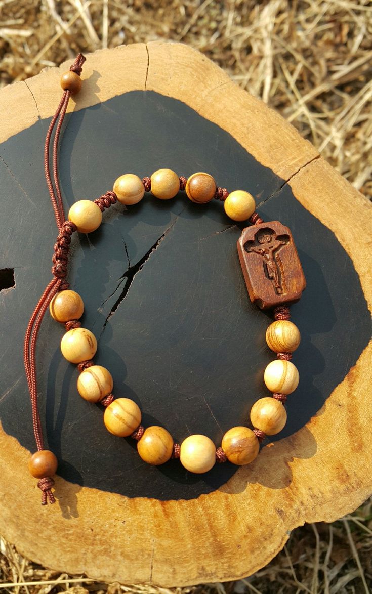 +. God Bless You. +. This is a Wooden Rosary Bracelet. +. It is knotted bracelet and it is adjustable . +. The crufix is carved in elevorate and three dementional shape. +. Beads are not round but beautifully angled. +.+.+.+.+. Materials +.+.+.+.+.+. Cross: Surinam Ebony Beads :olive tree +.+.+.+.+. Size +.+.+.+.+. Cross : 13.3mm(Width) *20mm(Height) Beads: 8mm +. Engraved characters(e.g. baptismal name, name,etc) on back side. It's Free engraving +. please send me characters that you want. +.Wo Spiritual Brown Rosary Bracelet For Gift, Handmade Brown Rosary Bracelet As Gift, Catholic Rosary Bracelet, Knotted Rosary, Mens Rosary, Wooden Rosary, Rosary Jewelry, Knotted Bracelet, Bracelet Knots