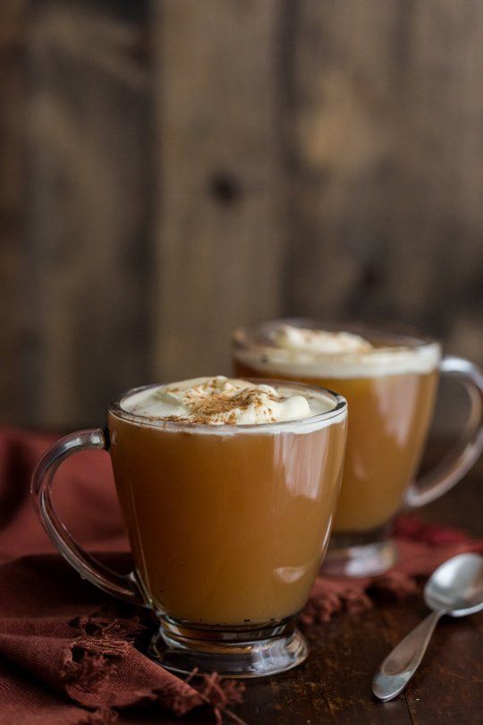 two glasses filled with hot chocolate on top of a table