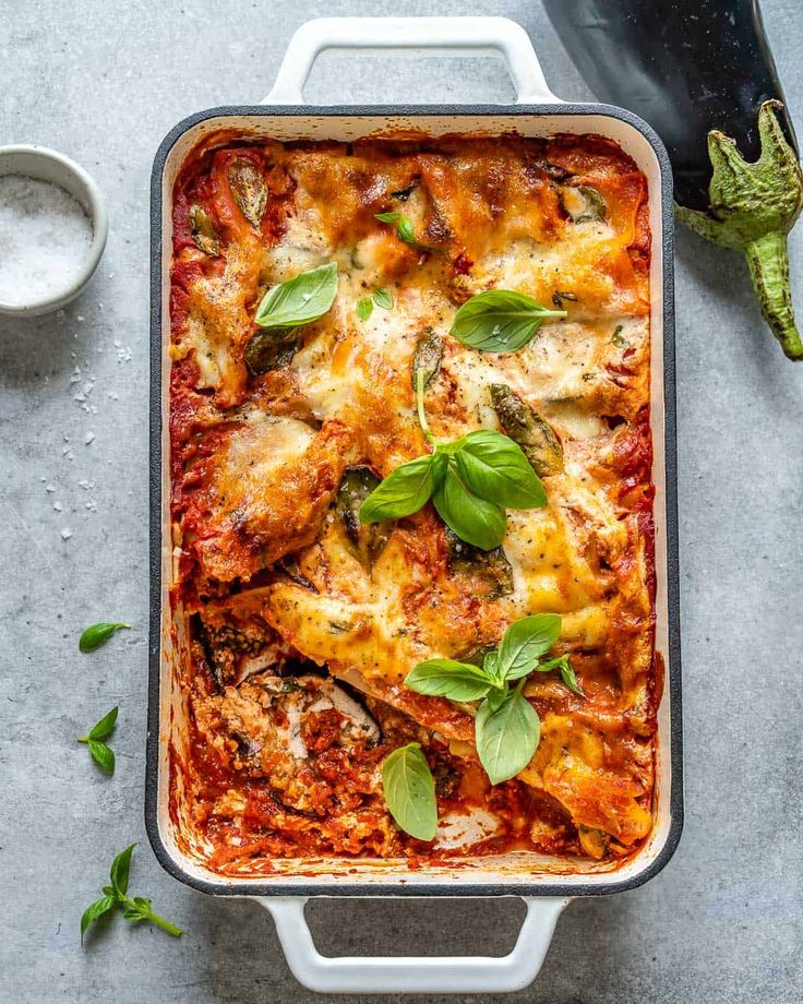 a casserole dish with spinach, cheese and sauce in it on a table