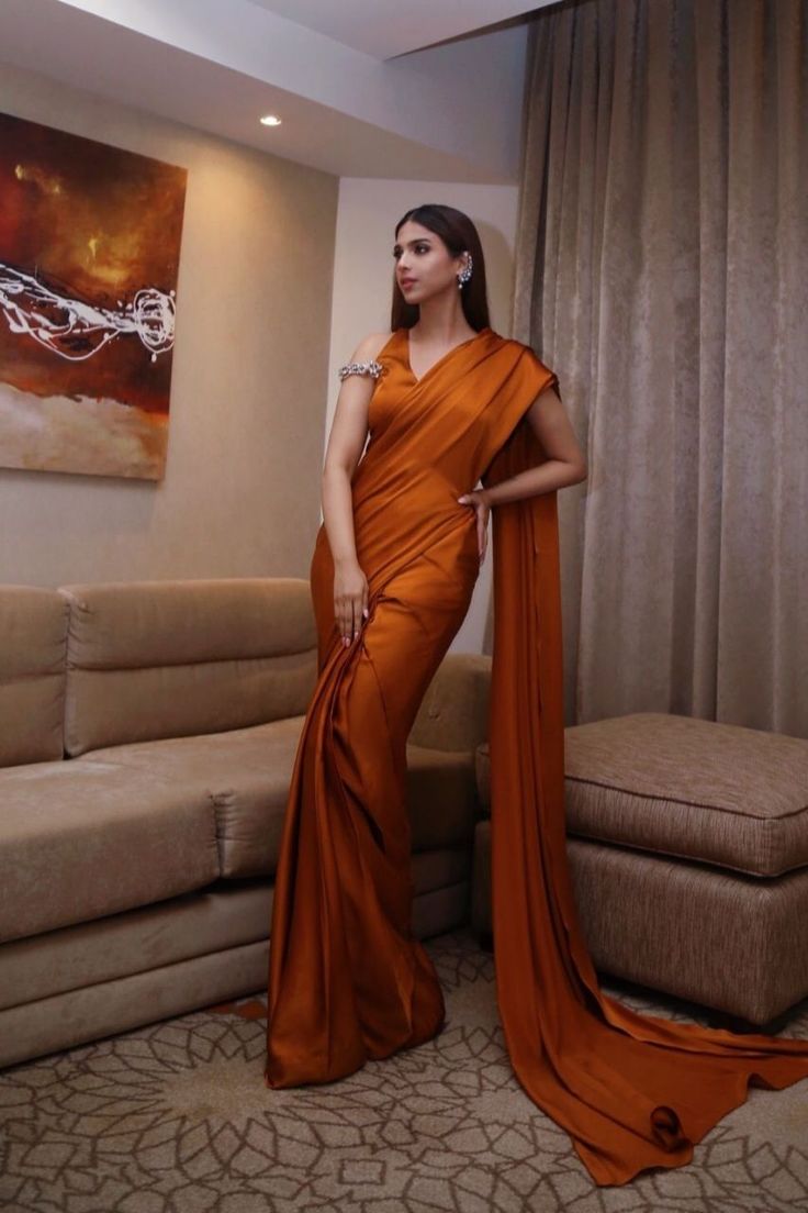 Charmeuse silk in this shade of burnt orange creates depth and a regality that is sure to impress with an updated feel on the traditional sari Keep it muted and elegant for added focus on the cut or pair it with bold jewellery for a dramatic look Orange Silk Pre-draped Saree, Orange Pre-draped Designer Saree For Festive Occasions, Elegant Silk Pre-draped Saree For Diwali, Festive Designer Orange Pre-draped Saree, Festive Orange Pre-draped Saree For Designer Wear, Silk Pre-draped Saree With Zari Work For Formal Occasions, Formal Silk Pre-draped Saree With Zari Work, Formal Draped Silk Saree, Elegant Silk Pre-draped Saree With Cutdana