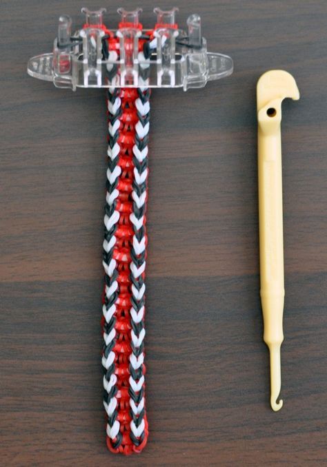 a toothbrush holder with two different colored braids and a plastic handle on a wooden table