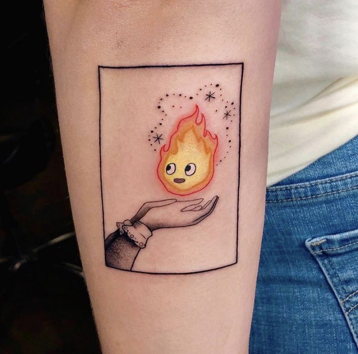 a woman's arm with a tattoo on it and an image of a hand holding a fire