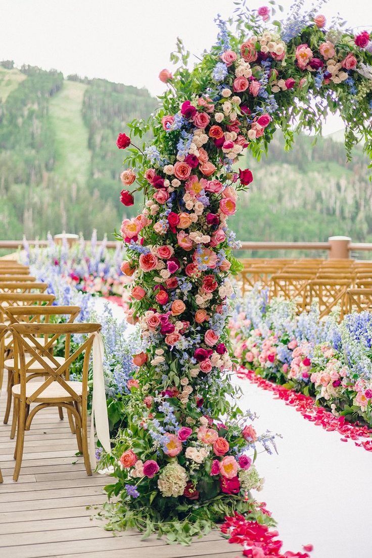 an outdoor ceremony setup with flowers and greenery