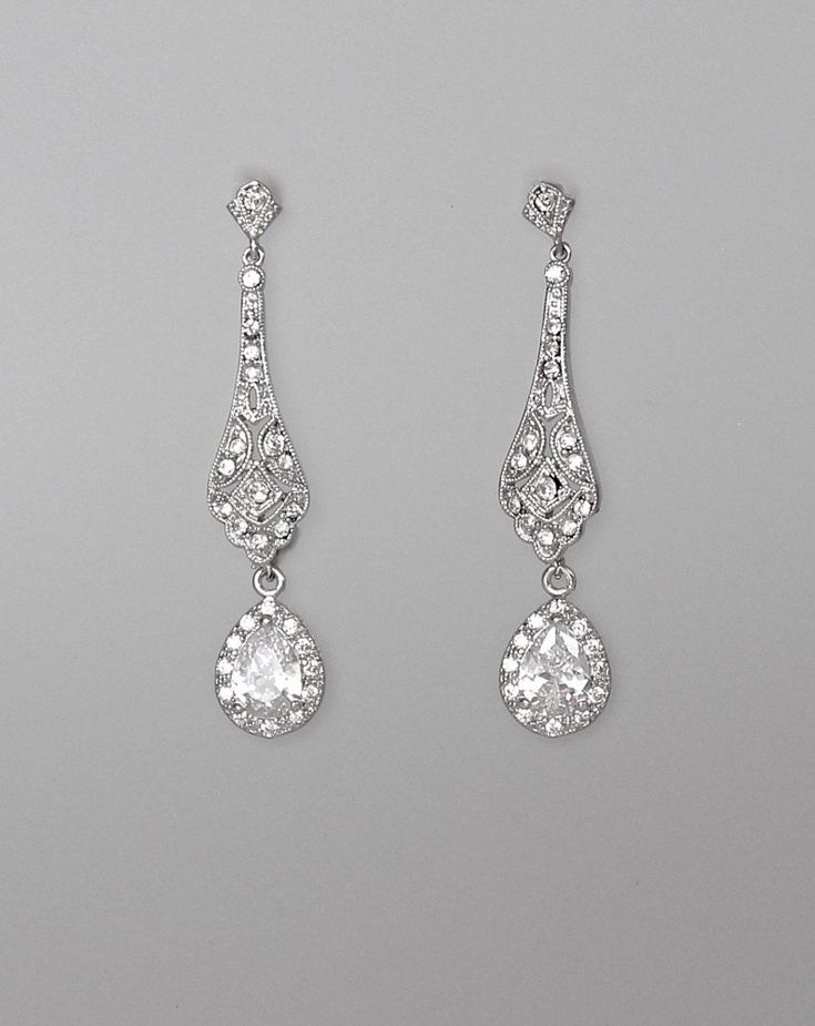 two pairs of diamond earrings on a gray background with clippings to the side