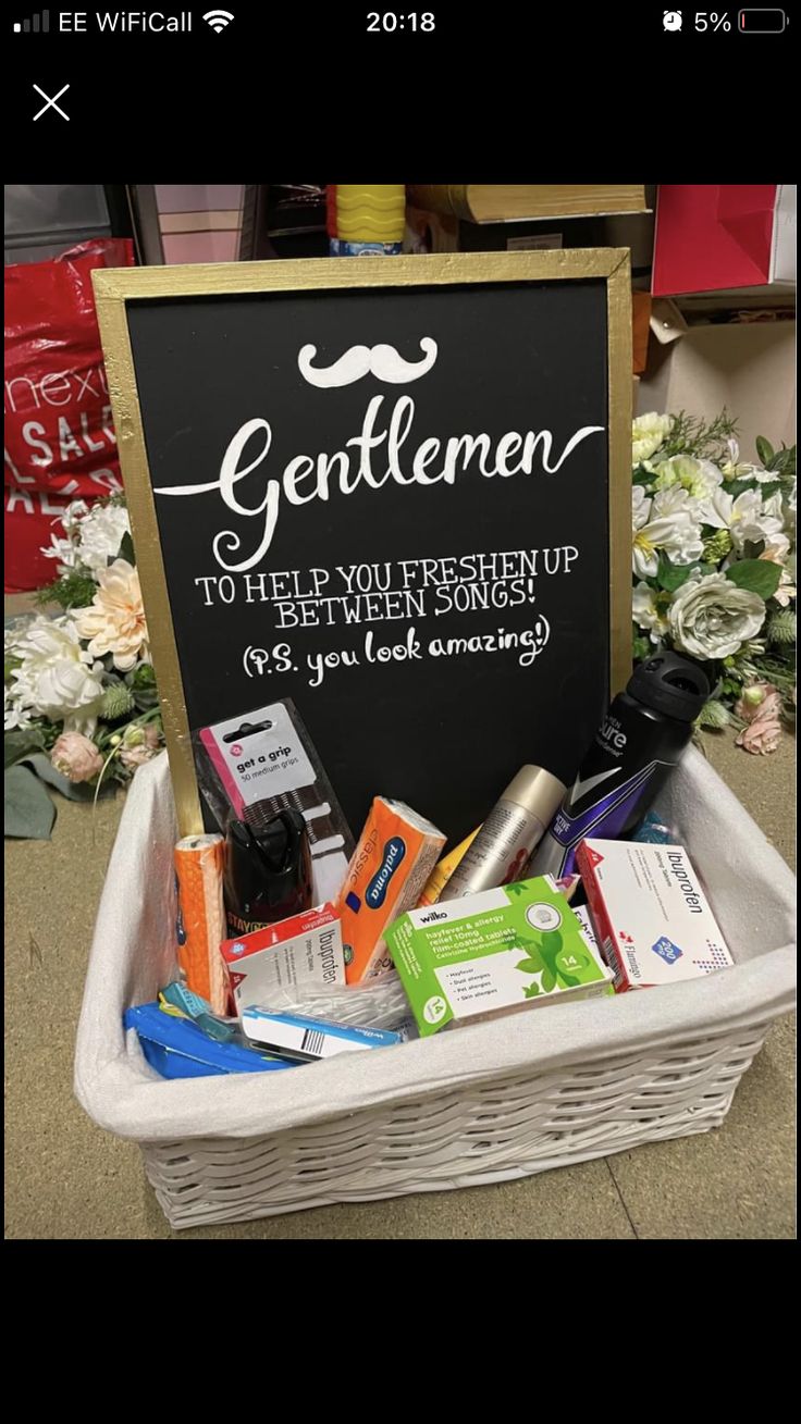 a white basket filled with lots of different items next to a sign that says gentlemen