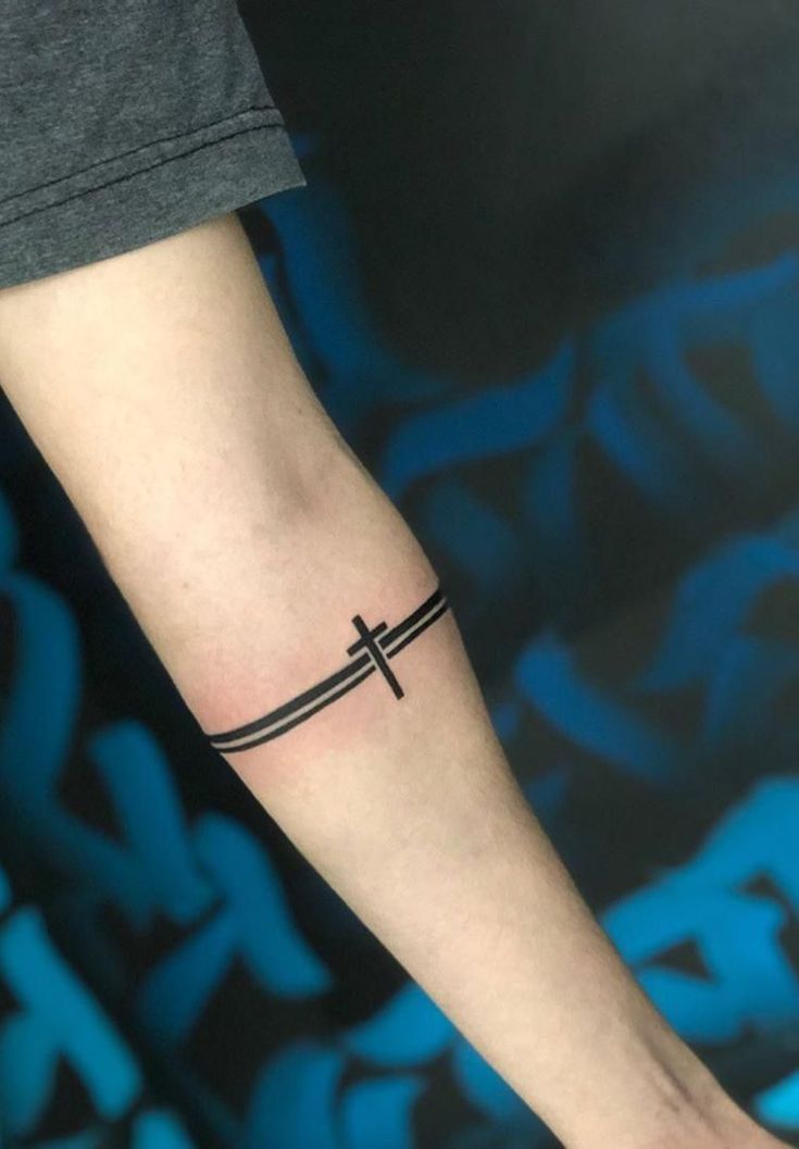 a person with a cross tattoo on their arm