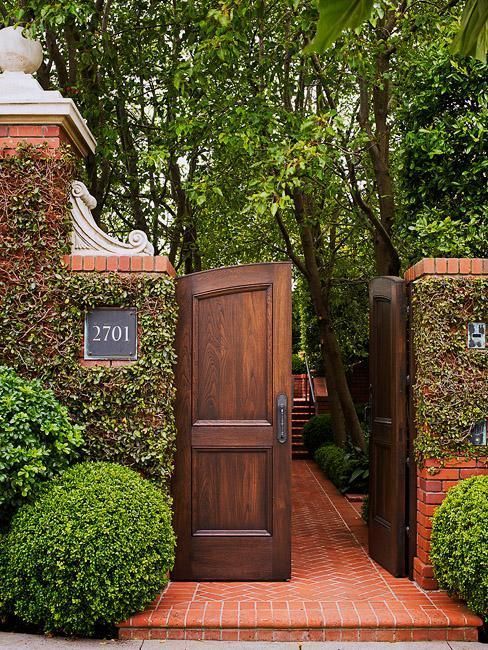 an entrance to a home surrounded by trees and bushes