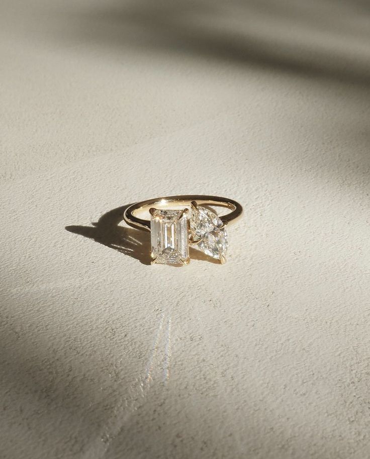 a diamond ring sitting on top of a white surface