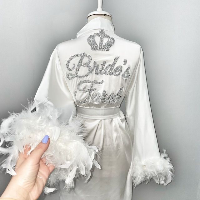 a bride's robe is being held by a hand