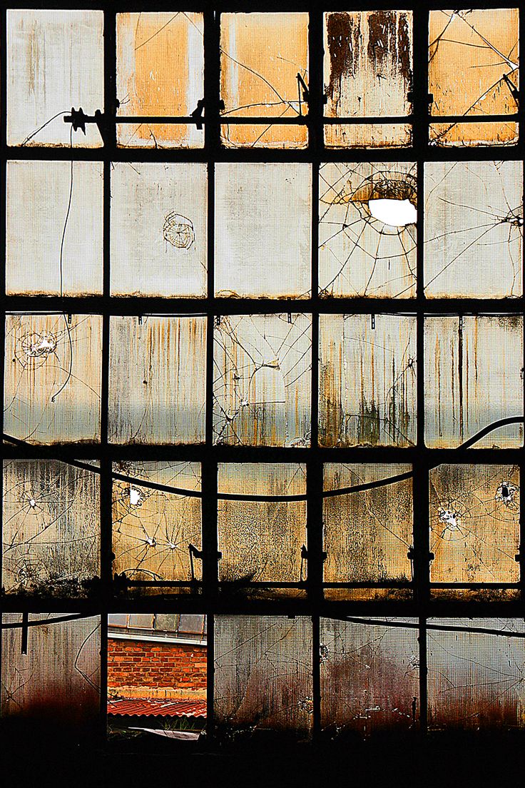 an old window with rusted metal bars in the center and water on the other side