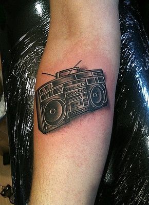 a person with a tattoo on their arm has a boombox tattooed on his arm