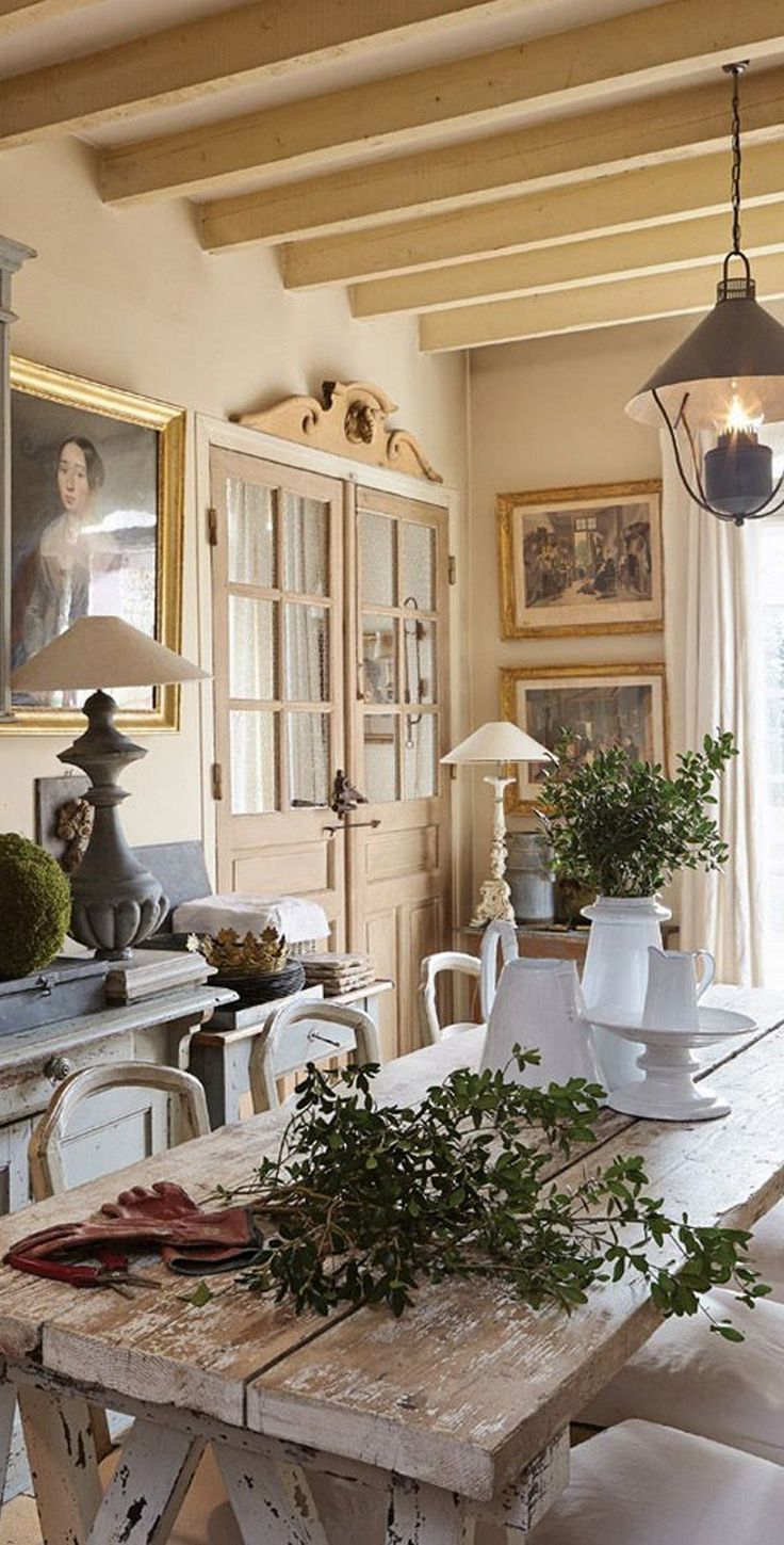 a dining room table with white chairs and potted plants on top of the table